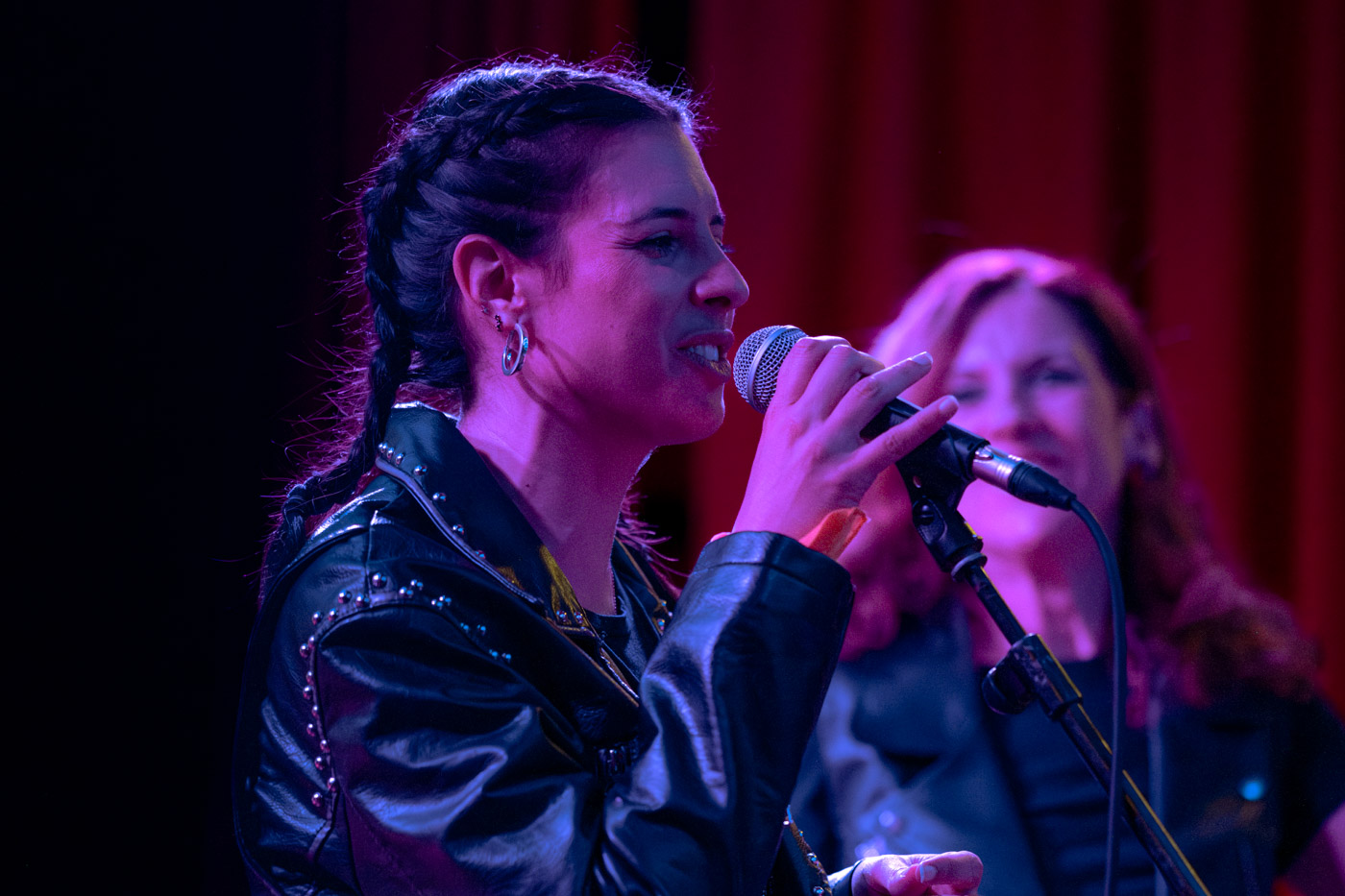 Cantante con micrófono actuando en el Junio EMEX Experience, cursos de música en Pozuelo Madrid
