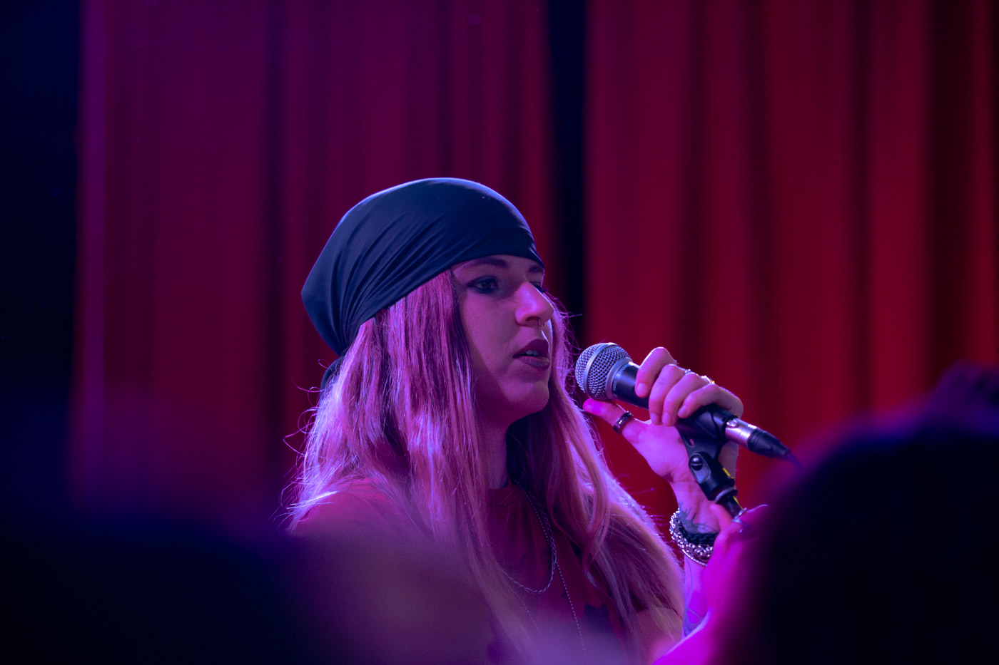 Cantante de EMEX Música interpretando en el escenario con luz de concierto
