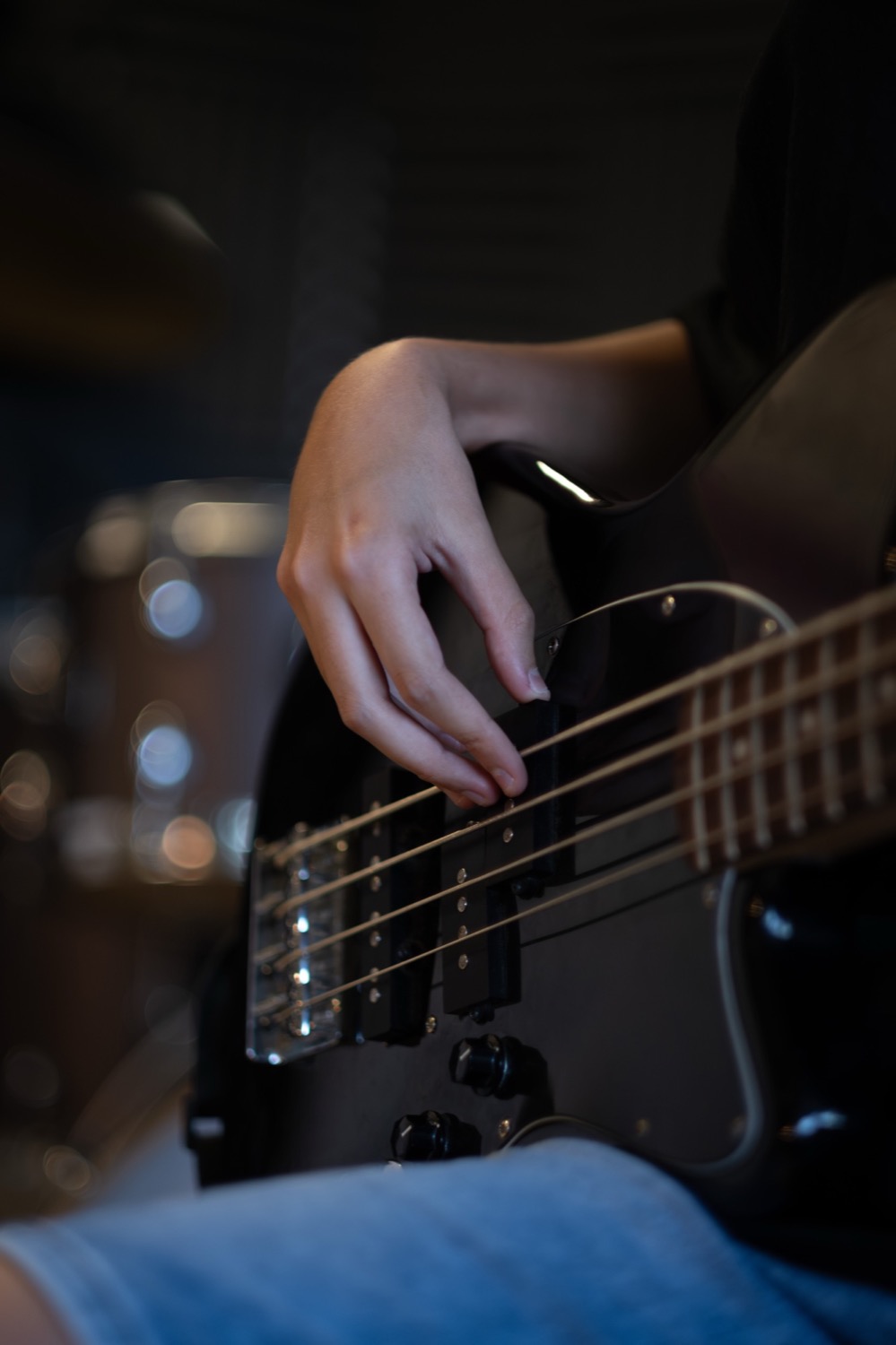 Detalle de mano tocando bajo eléctrico en clase de EMEX Música